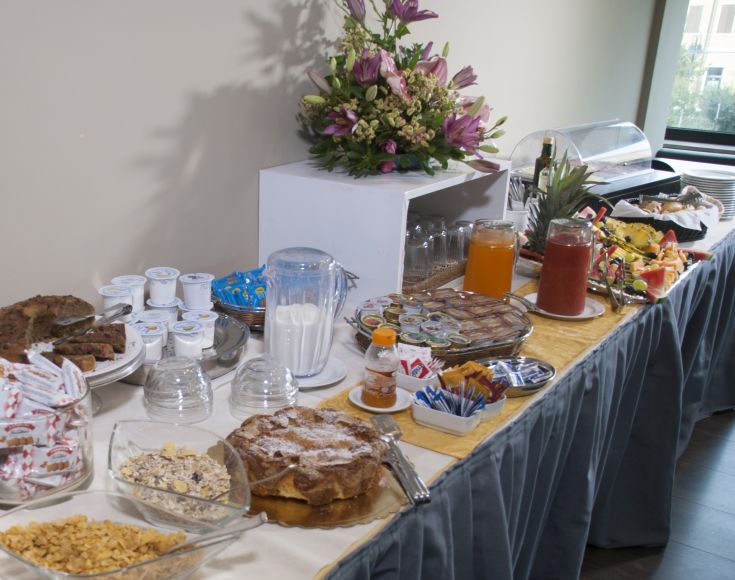 Colazione a buffet con una selezione di dolci, frutta fresca e bevande dissetanti.
