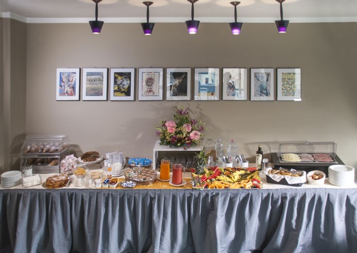 Buffet vario di piatti in un ambiente raffinato, con decorazioni floreali e dettagli semplici nell'arredamento.