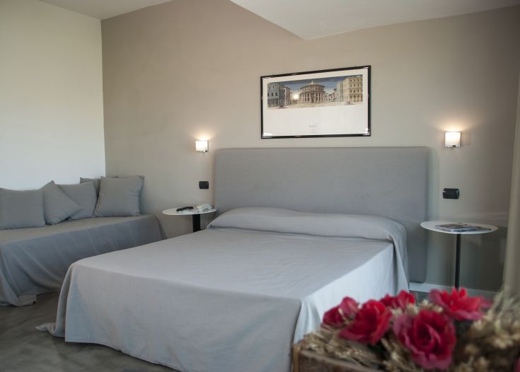 Camera semplice con letto matrimoniale e arredamento essenziale, ideale per un soggiorno confortevole.