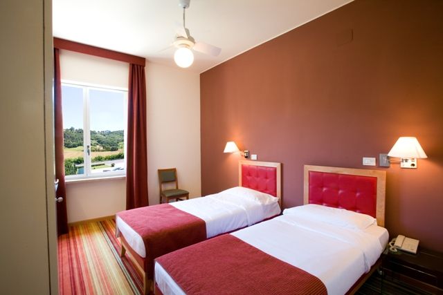 Simple and comfortable hotel room with single beds, perfect for relaxing moments.