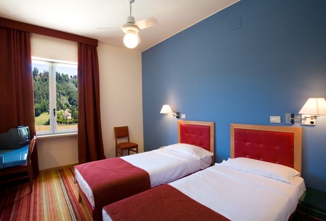 Bright and welcoming room at Hotel Arca, featuring single beds and a view of the garden.
