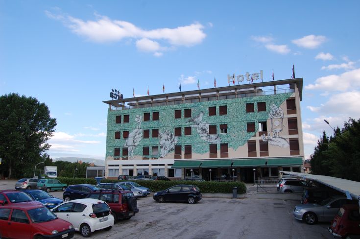 Hotel Arca is a modern structure featuring a mural that reflects an urban and contemporary style.