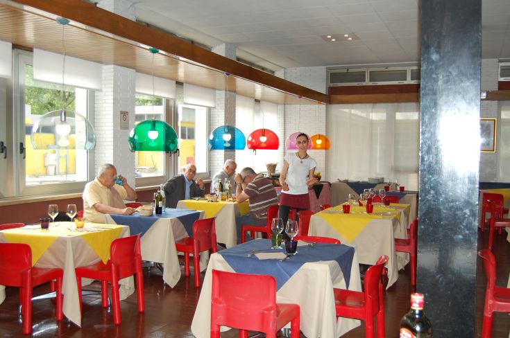 A cozy restaurant with colorful tables and vintage lamps, perfect for lunches with friends.