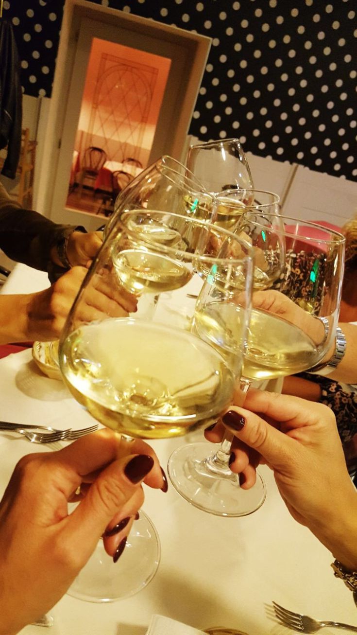 A group of friends toasting with white wine glasses in a cheerful and friendly atmosphere.
