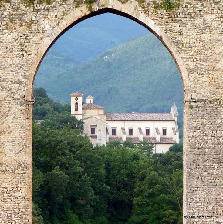 View of an ancient monastery nestled among green hills and typical landscapes.