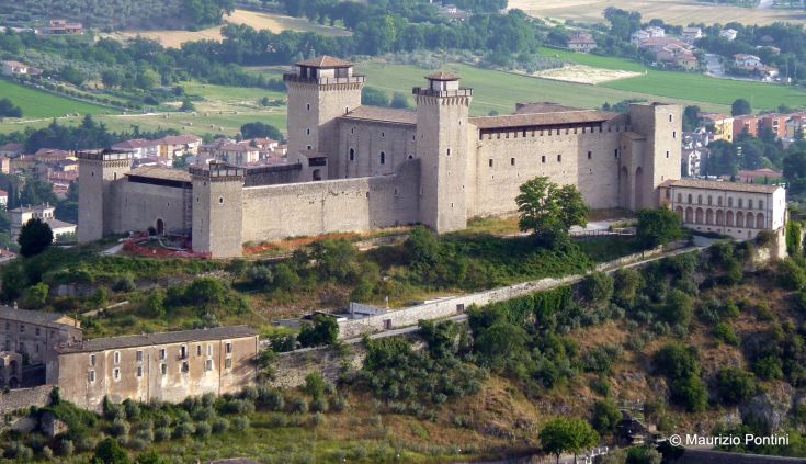 A well-preserved castle stands on a green hilly landscape, reflecting the region's architectural style.