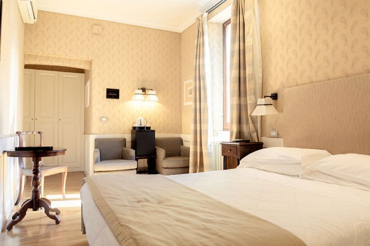 Gemütliches Hotelzimmer mit einfacher Einrichtung und einem Entspannungsbereich. Perfekt für einen komfortablen und ruhigen Aufenthalt.