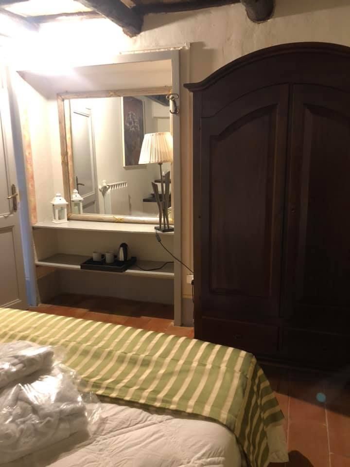 Camera semplice con armadio e piccolo spazio per cucinare, perfetta per un soggiorno tranquillo.