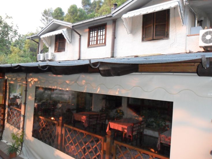 Ecke eines Bauernhofs mit Außentischen und Blick auf eine üppige, grüne Landschaft.