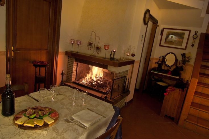 Eine gemütliche Atmosphäre mit einem angezündeten Kamin, ideal für einen romantischen Abend bei Kerzenlicht.