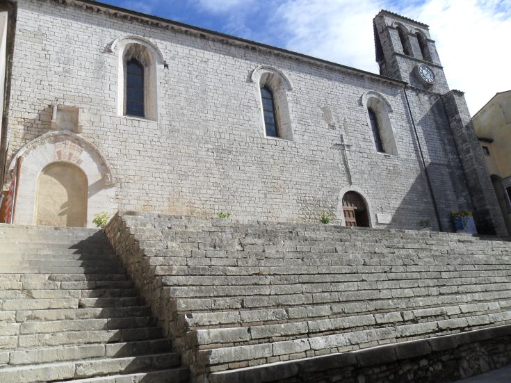 Die Fassade eines alten religiösen Gebäudes mit Steinstufen und einem klaren Himmel.