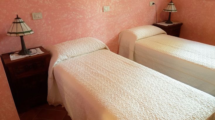 Simple room with single beds and understated decor, perfect for a restful stay.