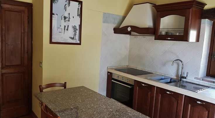 Modern and practical apartment kitchen with a stove and spacious countertops.