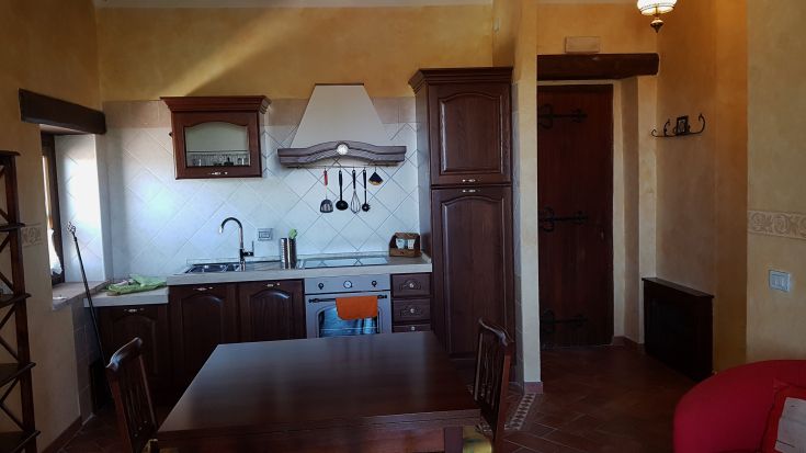 Cozy kitchen with wooden furniture and traditional details, perfect for family gatherings.