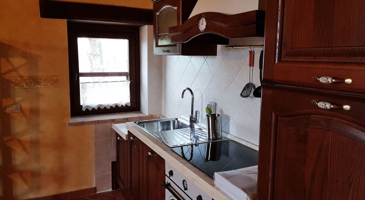 Kitchen of the Lavanda apartment featuring wooden furniture and modern utensils.
