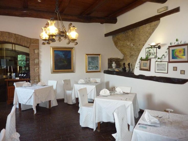 Un ristorante con tavoli apparecchiati e decorazioni sobrie. Atmosfera accogliente e confortevole.