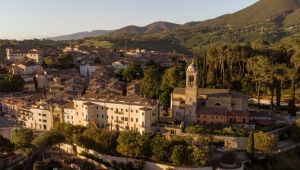 Image du Palazzo Sangemini, une structure historique située dans un paysage verdoyant et montagneux.