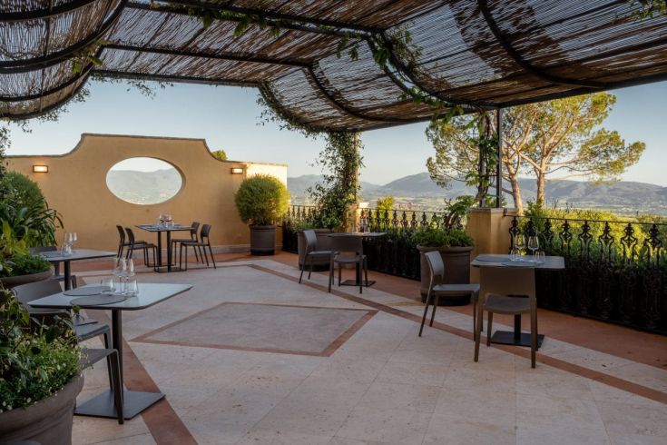 Espace extérieur élégant avec vue sur les collines environnantes, idéal pour un repas serein.