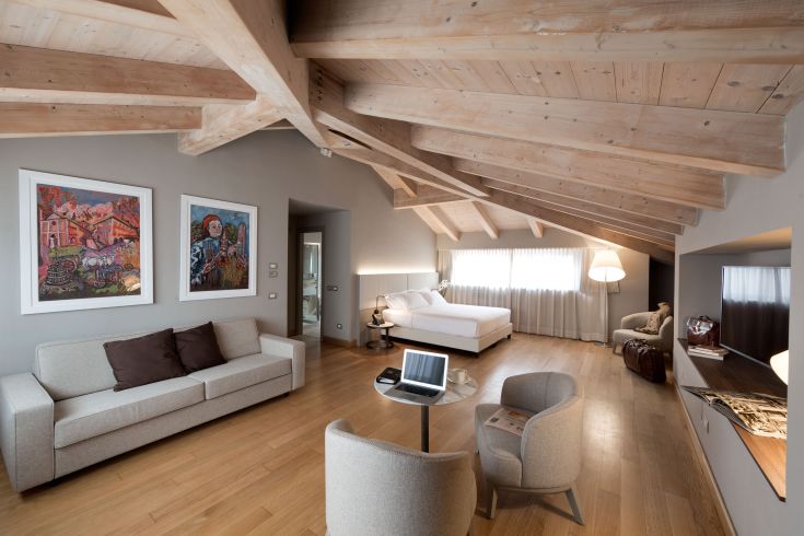 Chambre moderne avec poutres apparentes, offrant une ambiance épurée et confortable.