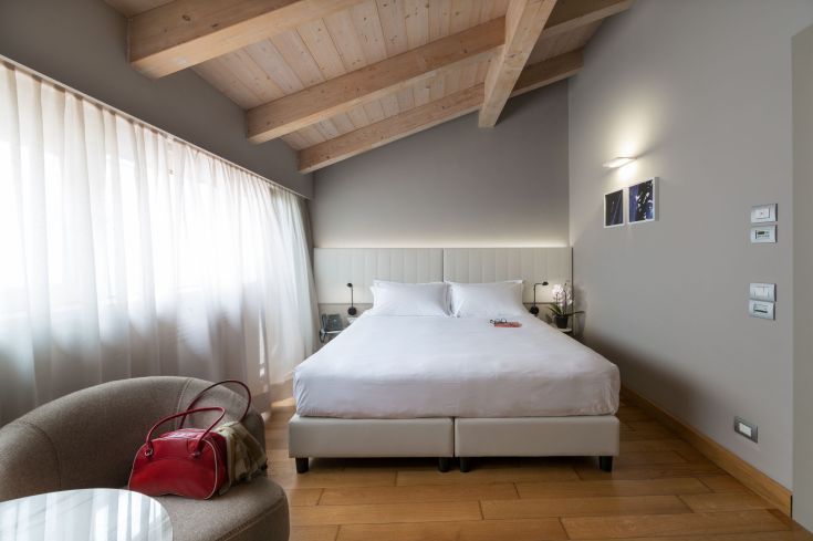 Chambre confortable avec des lits douillets et une grande fenêtre, créant une atmosphère accueillante et paisible.