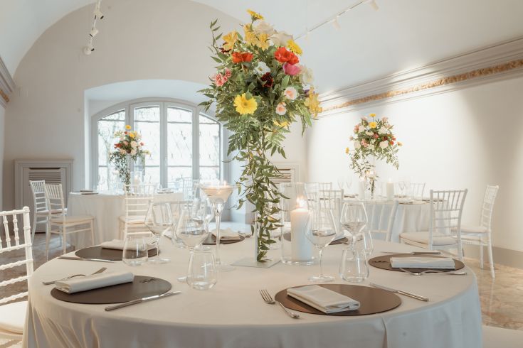 Espace événementiel avec des tables décorées et des arrangements floraux, idéal pour des fêtes et des célébrations.