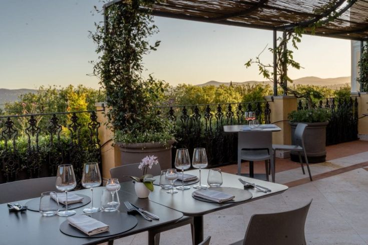 Restaurant simple avec une vue panoramique sur des collines et des jardins bien entretenus.