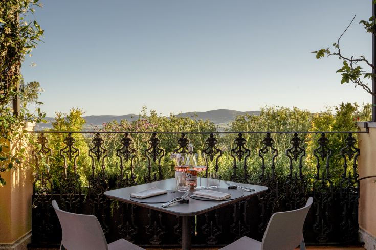 Table à l'intérieur d'un restaurant immersé dans la nature, avec une vue sur les paysages verts de l'Ombrie.