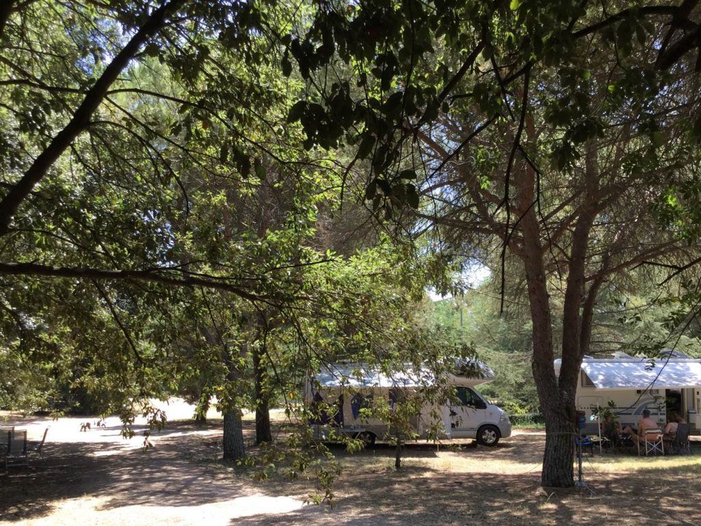 A campsite surrounded by vegetation, featuring shaded and equipped areas for tents. Perfect for a nature escape.