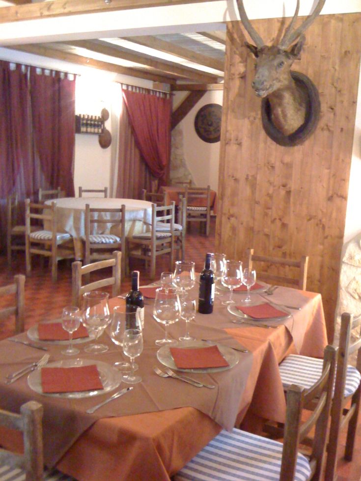 Un ristorante in legno, caratterizzato da tavoli apparecchiati con cura e decorazioni in stile rustico.