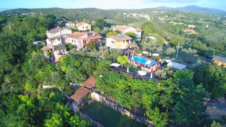 Ein Bauernhaus in der üppigen umbrischen Landschaft, mit einem Pool und renovierten Apartments im rustikalen Stil.