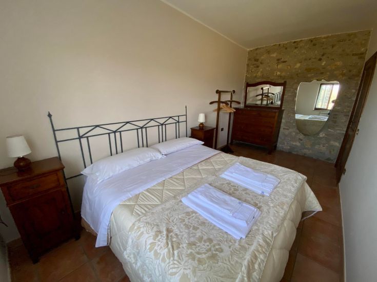 Einfache Zimmer mit Holzmöbeln und dekorativen Details, ideal für einen komfortablen Aufenthalt.