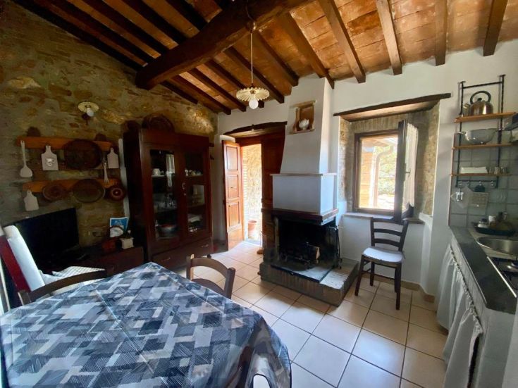 Eine Landhausküche mit Mauerwerk, einem Kamin und einer warmen, rustikalen Atmosphäre.