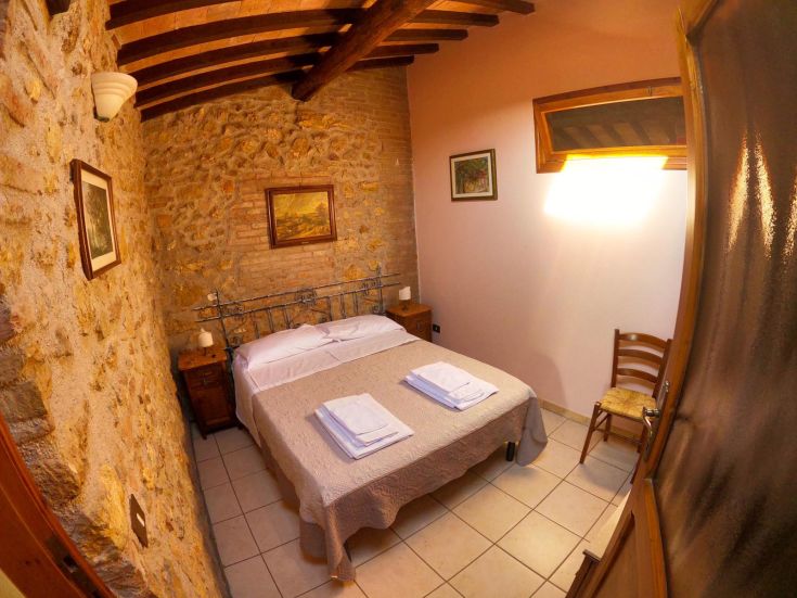 Gemütliches Zimmer mit Steinelementen, minimalistischer Stil und viel Tageslicht.