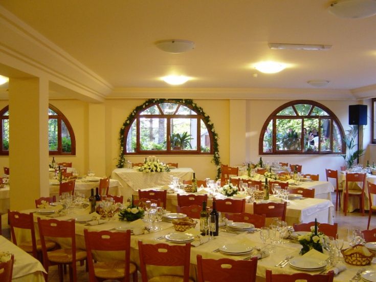 Salle de restaurant spacieuse avec des décorations simples et des tables bien disposées, idéale pour des événements privés.