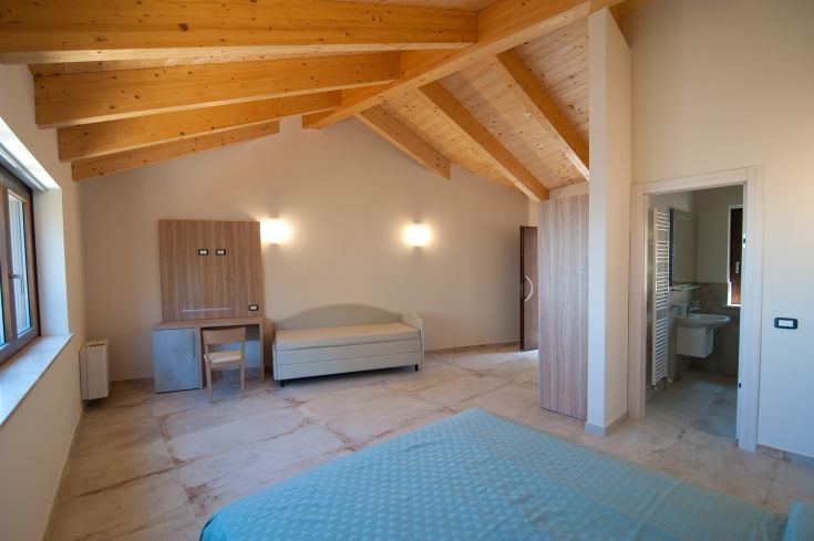 Chambre simple avec un plafond en bois et des meubles contemporains dans un espace bien décoré.