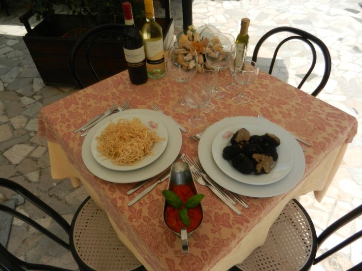 Un tavolo apparecchiato con piatti di pasta e funghi, in un ambiente tranquillo e invitante.