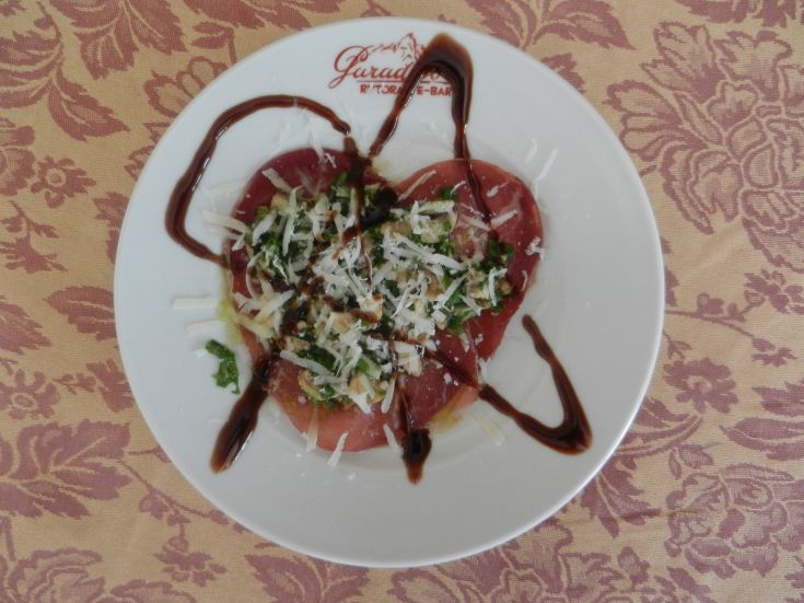 Piatto con forma a cuore, preparato con ingredienti freschi e guarnizioni semplici.