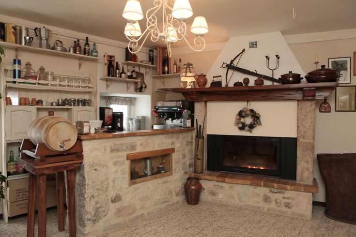 Accogliente ambiente di un agriturismo con camino e arredo rustico, perfetto per momenti di relax.