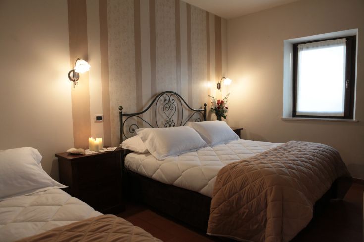 Camera semplice con letti comodi e un arredamento pratico, perfetta per un soggiorno tranquillo.