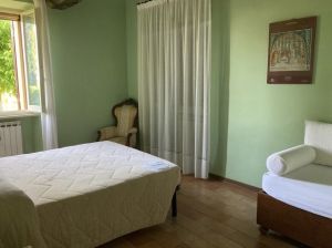 A simple room designed with green walls and classic style furniture, perfect for relaxation.