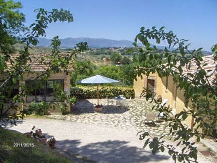 A tranquil property surrounded by olive trees and hills, featuring two guest buildings.