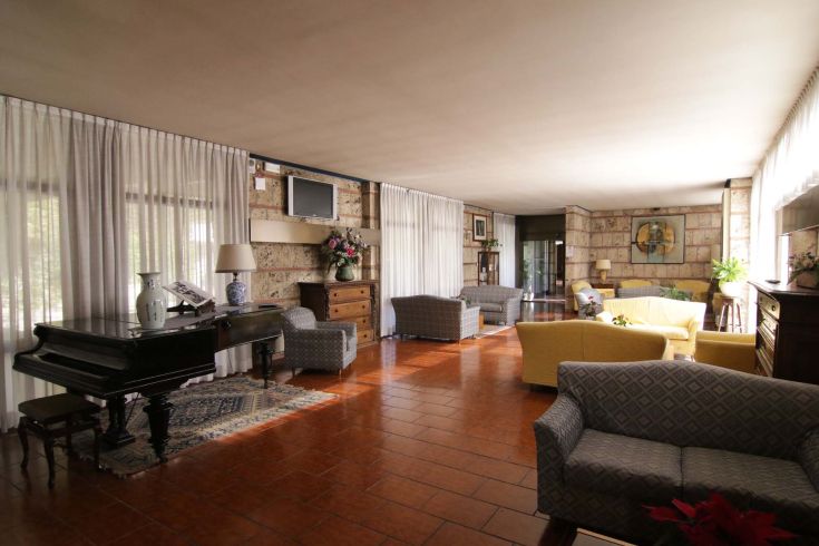 A simple yet elegant hotel lounge featuring a piano, perfect for relaxation.