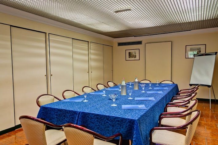 A meeting room with a blue table and neatly arranged chairs, perfect for gatherings and presentations.