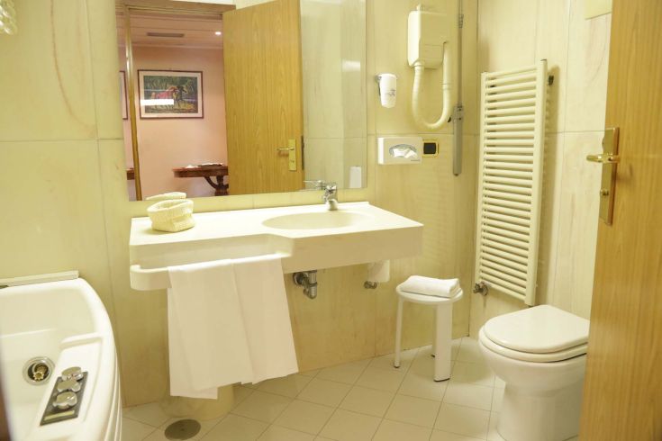 Modern hotel bathroom with functional furnishings and attention to detail for guest comfort.