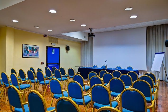 Conference room setting with blue chairs and a table, perfect for events or meetings.