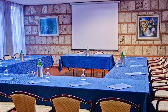 A simple meeting space with blue tables and an area suitable for events.