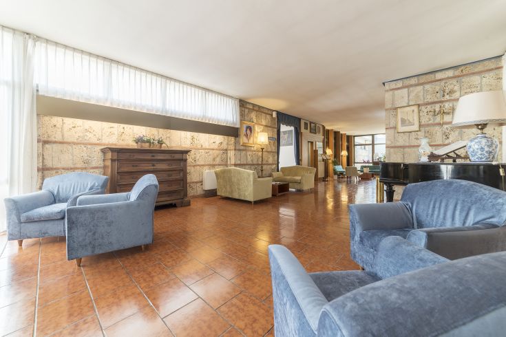 A well-lit and spacious hotel room at Hotel Garden, perfect for guest relaxation.