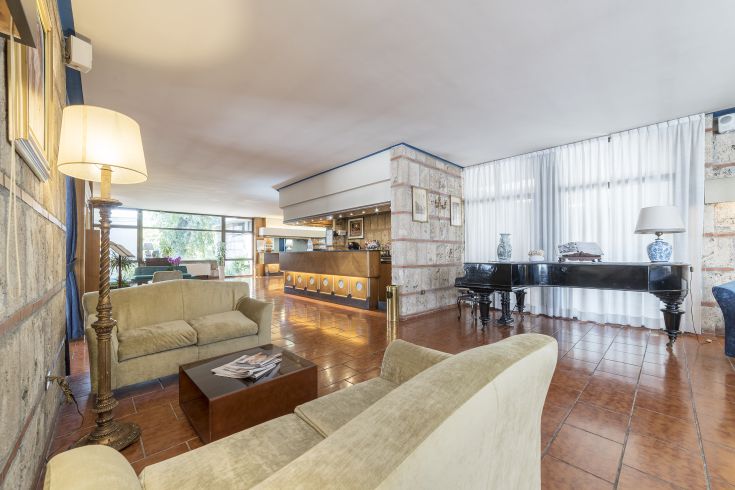 Lobby of the Garden Hotel, a spacious and bright area with simple, functional furnishings.