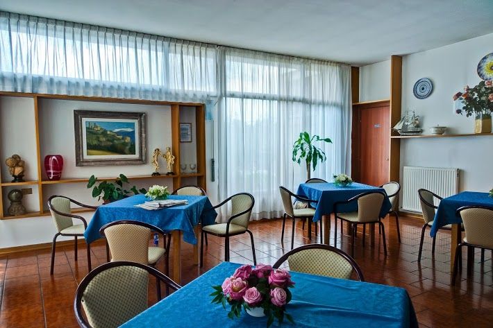 A restaurant room featuring carefully set tables, illuminated by natural light streaming through the windows.