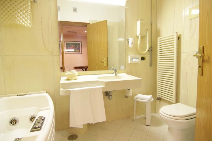 Modern and practical hotel bathroom featuring a bathtub, sink, and minimalist style fixtures.